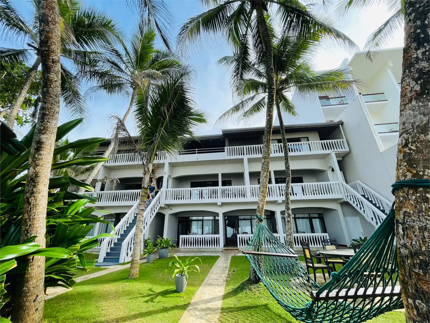 Suite Lanka garden exterior with palms and hammock